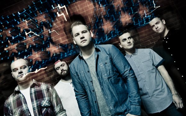HD desktop wallpaper featuring a group of people with the tag Beartooth, posing against a brick wall with dynamic blue lighting effects.
