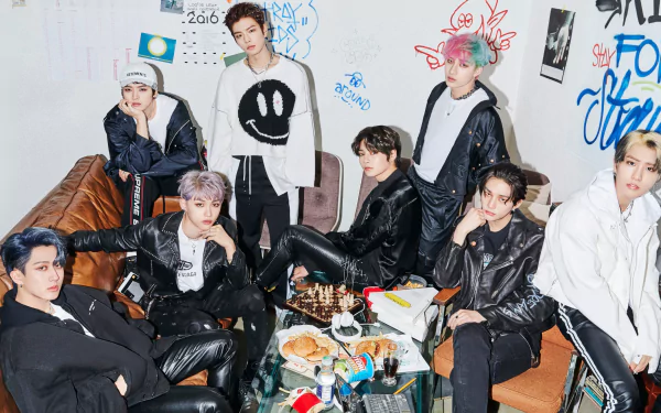 HD PC desktop wallpaper featuring the K-pop boy band Stray Kids posing together in a room filled with graffiti and casual decor.
