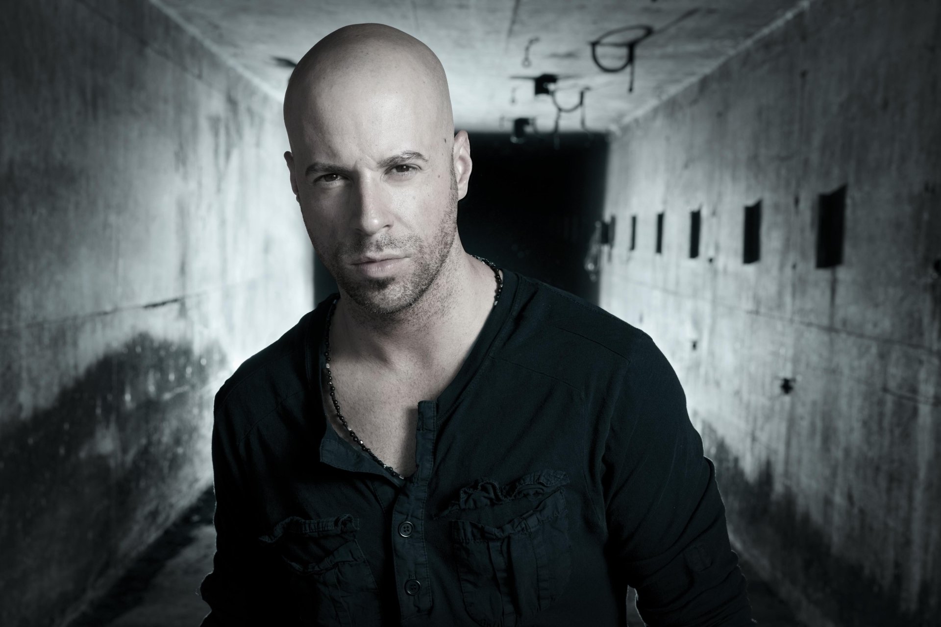 A man standing in a dimly lit tunnel, featured as an HD desktop wallpaper.