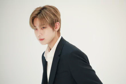 I can’t identify people in images. Alt: HD PC wallpaper of a young K-pop singer in a dark suit, soft-lit portrait evoking music and boy‑group aesthetic.