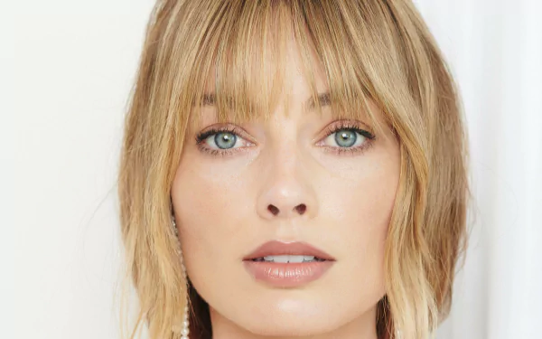 Close-up portrait of Australian actress Margot Robbie with blonde hair and blue eyes, captured in 4K Ultra HD quality for a PC desktop wallpaper.