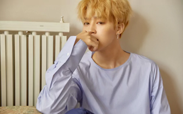 A 4K Ultra HD desktop wallpaper of Jimin (Park Jimin) from BTS, a K-pop singer, posing thoughtfully in a light blue shirt against a neutral background.
