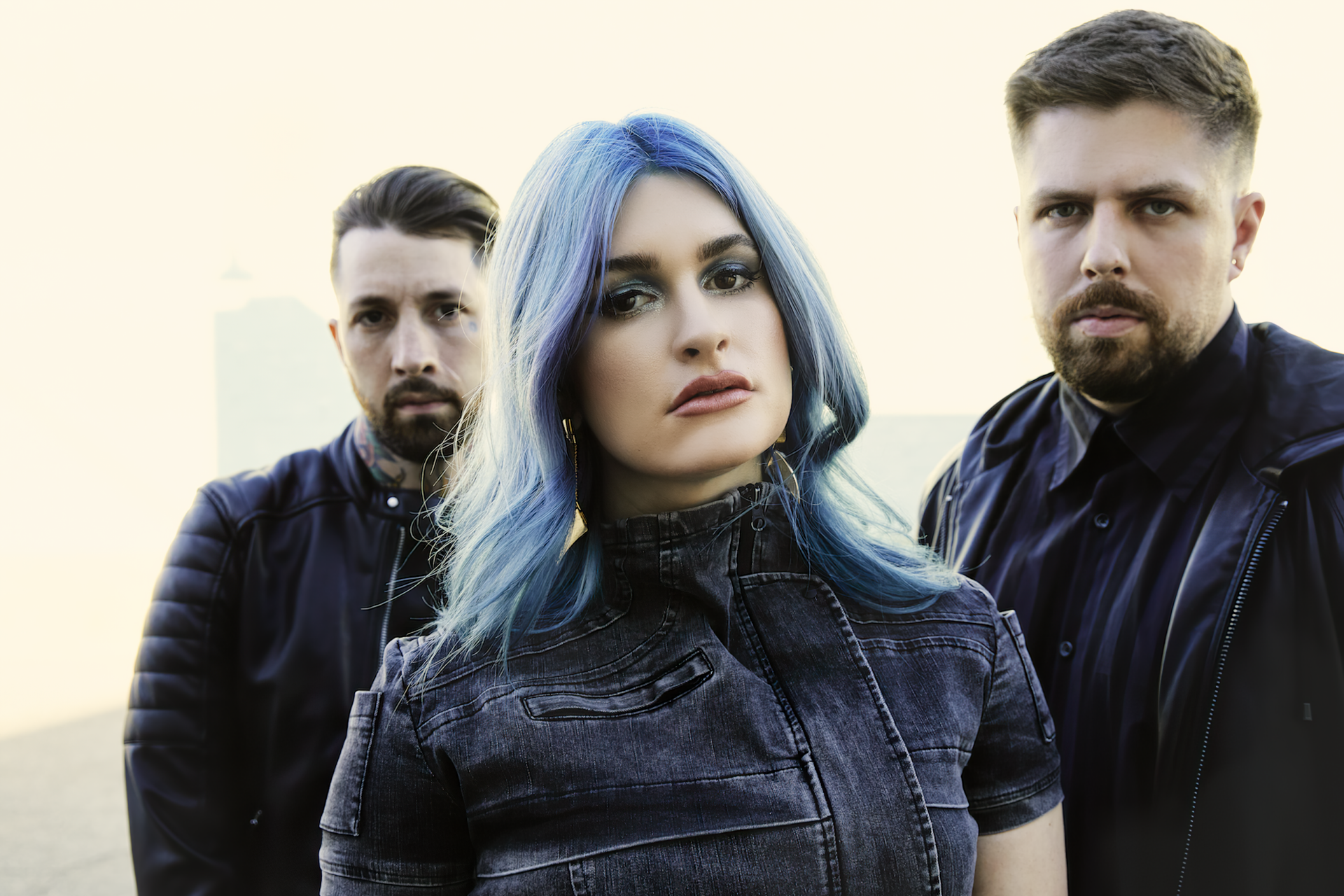 A striking HD wallpaper featuring the band Spiritbox, showcasing three members with intense expressions against a soft background, embodying the spirit of their music.