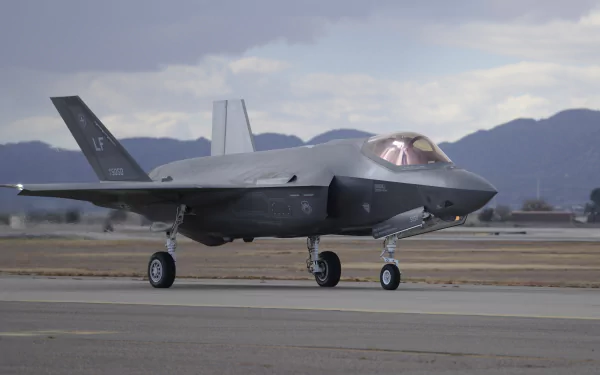 Lockheed Martin F-35 Lightning II warplane jet fighter on a runway with mountain backdrop — military stealth aircraft, 4K Ultra HD PC desktop wallpaper.
