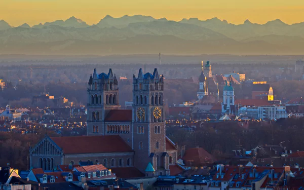 4K Ultra HD desktop wallpaper featuring a cityscape with prominent religious church towers against a backdrop of distant mountains at sunset.