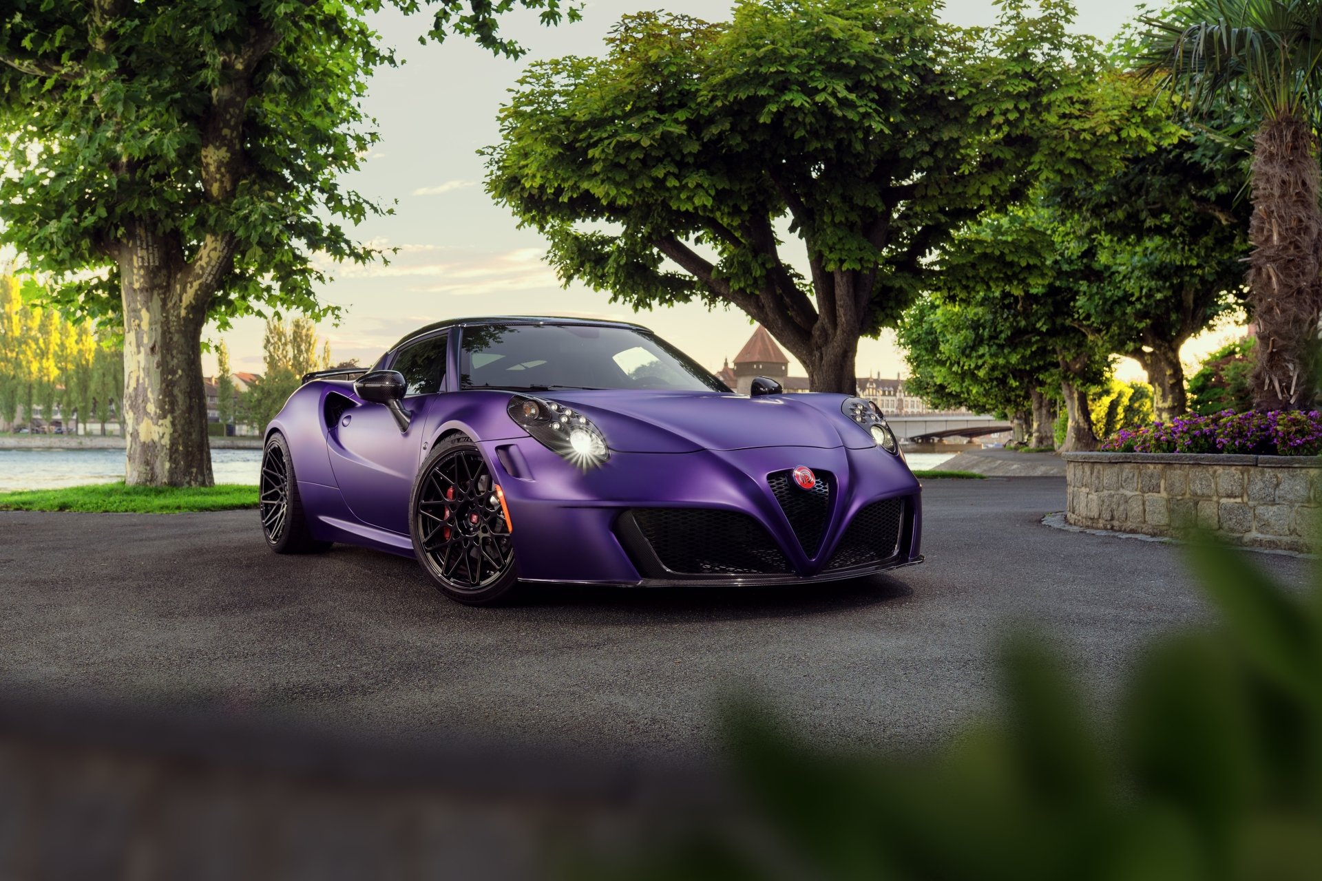 A sleek purple Alfa Romeo 4C car parked on a tree-lined street, captured in stunning 4K Ultra HD as a PC desktop wallpaper and background.