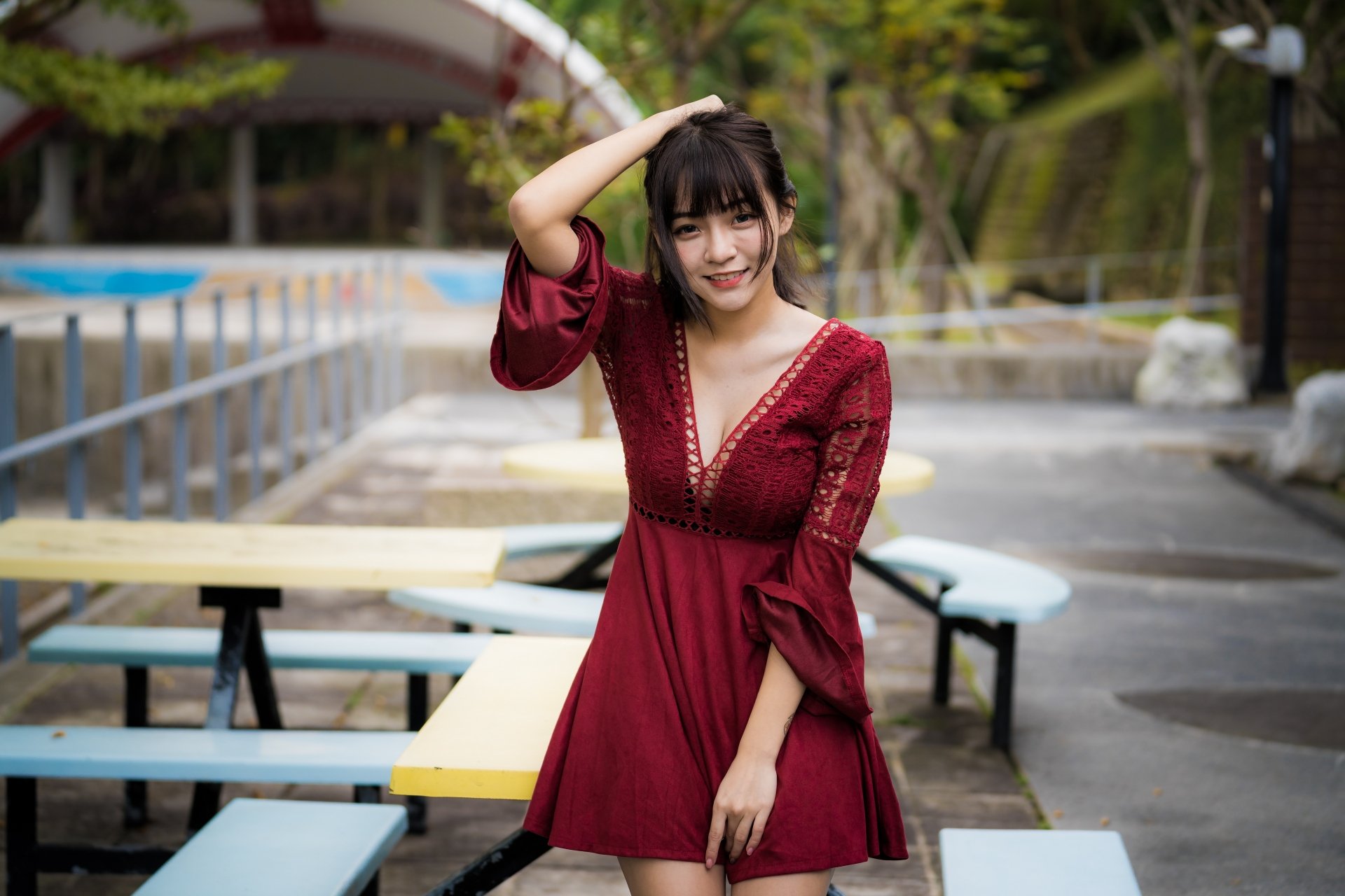 A smiling Asian woman with brunette hair wearing a red dress poses outdoors, captured in vibrant 4K Ultra HD quality for a PC desktop wallpaper.