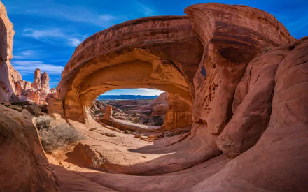 HD desktop wallpaper showcasing a natural sandstone arch at Arches National Park against a vibrant blue sky, highlighting stunning desert rock formations and nature.