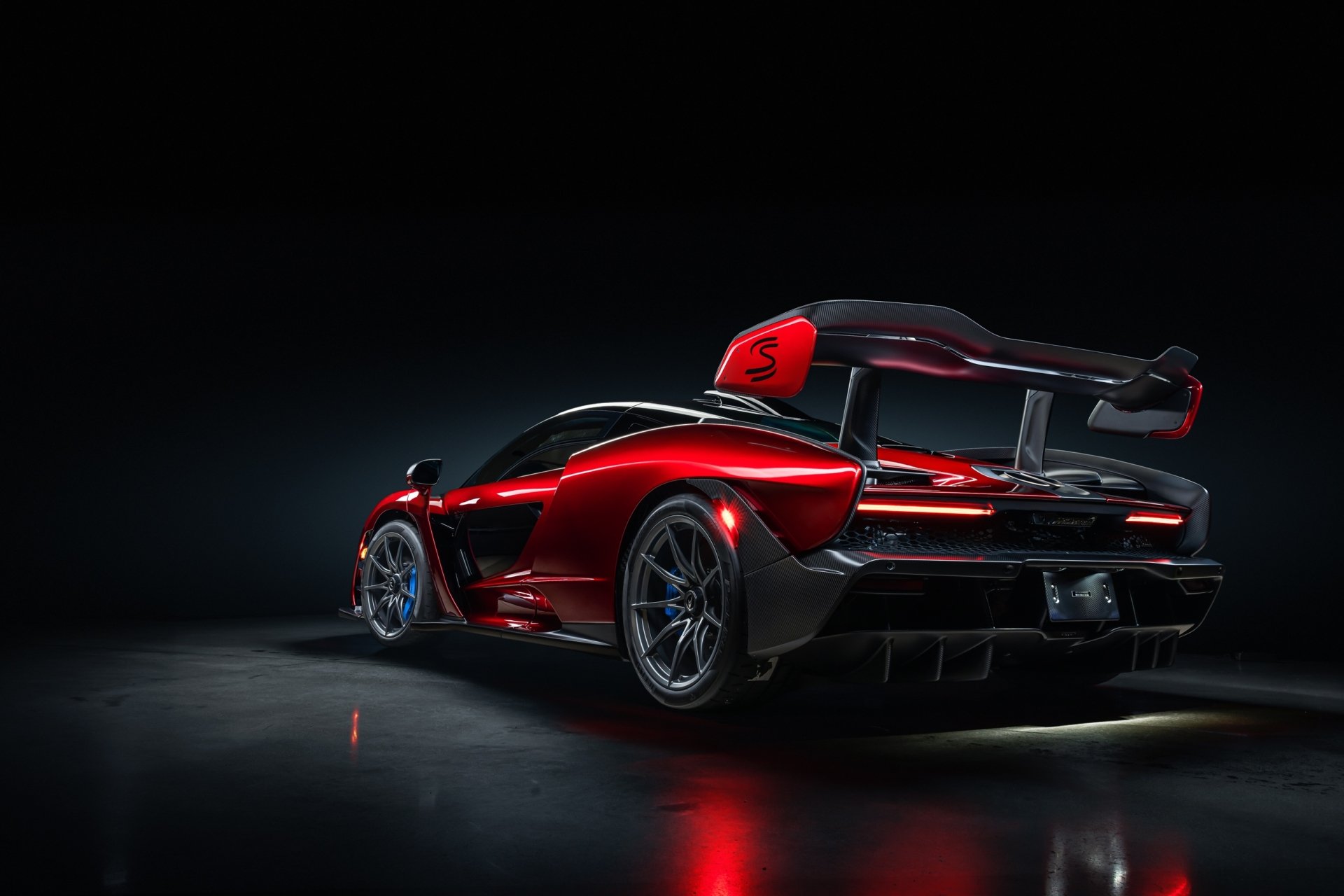 HD desktop wallpaper featuring a striking red McLaren Senna supercar with sleek aerodynamic design, showcased against a dark background.