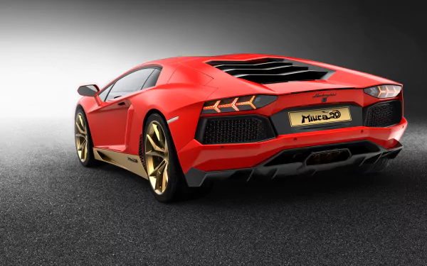 Red Lamborghini Aventador LP 700-4 supercar, rear three-quarter view with gold wheels on dark pavement — 2K Quad HD PC desktop wallpaper/background.