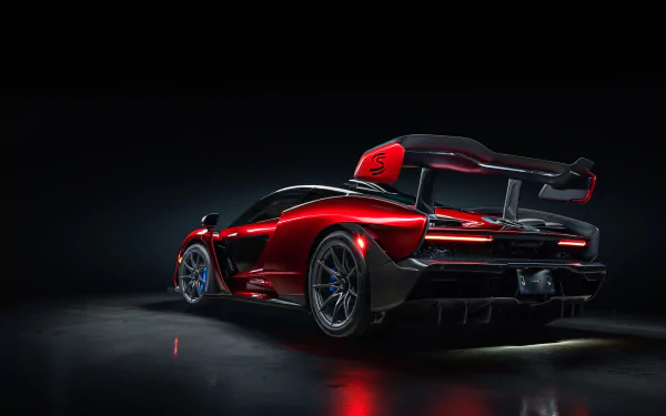 HD desktop wallpaper featuring a striking red McLaren Senna supercar with sleek aerodynamic design, showcased against a dark background.