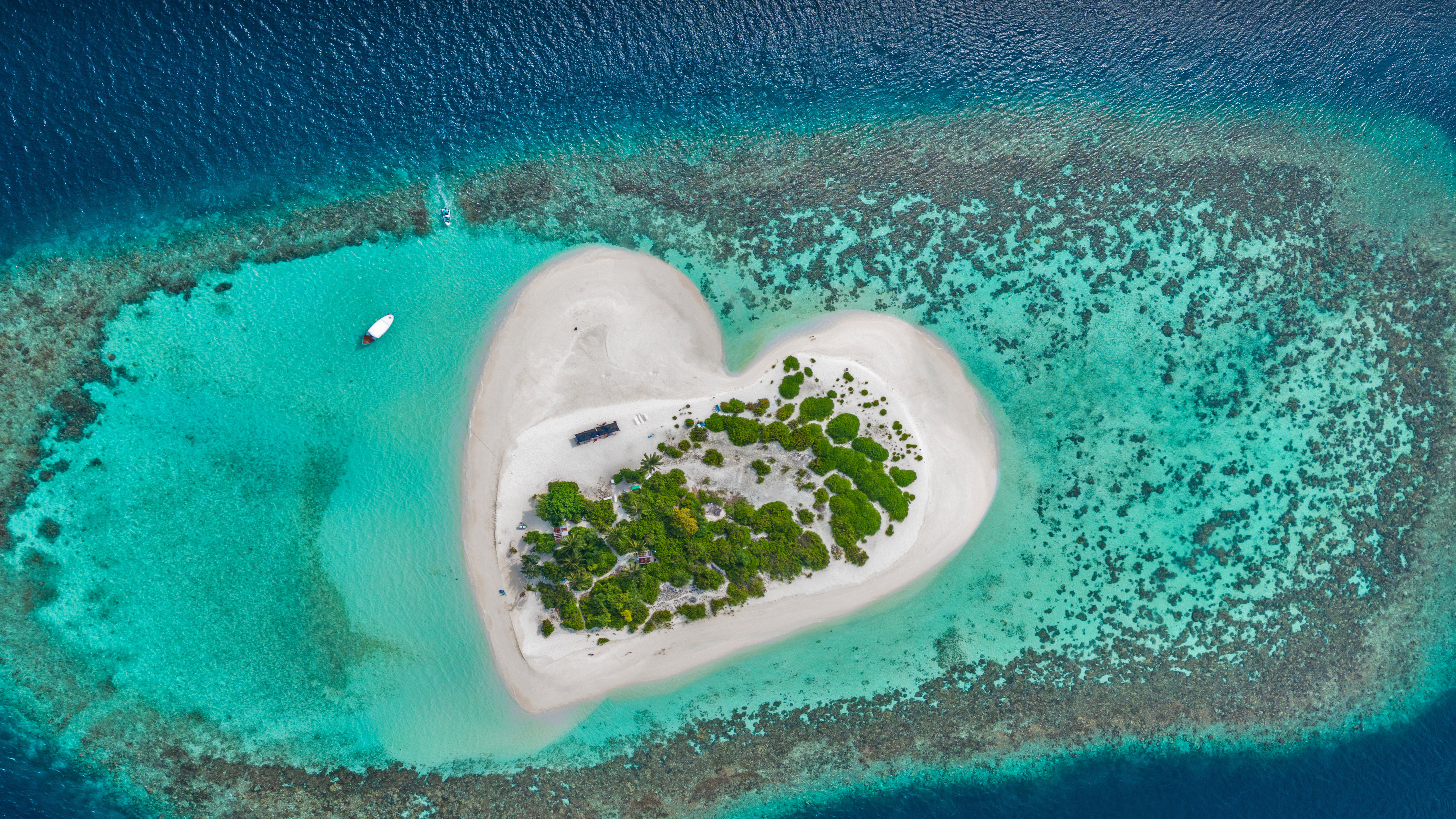 Heart-shaped island with sandy beach, offshore coral reef, Indian Ocean, Maldives by Willyam Bradberry