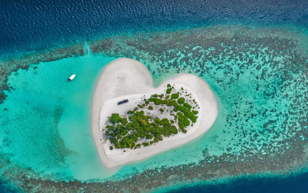  Heart-shaped island with sandy beach, offshore coral reef, Indian Ocean, Maldives by Willyam Bradberry