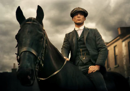 4K TV-show desktop wallpaper: flat-capped man in a period suit riding a black horse beneath stormy skies, Peaky Blinders aesthetic.