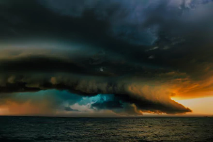 Dramatic cloud formation over the ocean at sunset, captured in stunning 4K Ultra HD for a nature-themed PC desktop wallpaper.