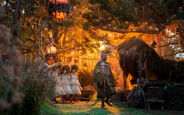 A detailed 4K Ultra HD desktop wallpaper from the TV show The Lord of the Rings: The Rings of Power featuring a woodland scene with characters and glowing lanterns.