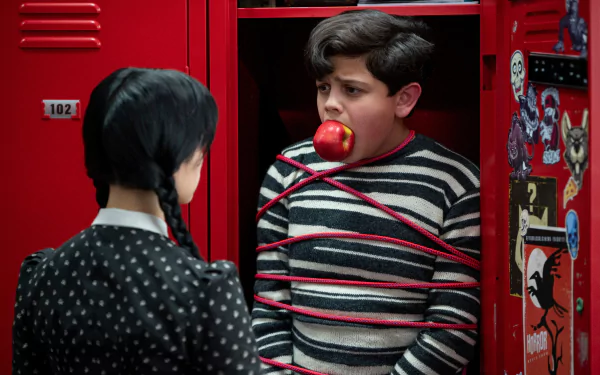HD PC desktop wallpaper featuring Issac Ordonez as Pugsley tied with red rope in a red locker, from the TV show Wednesday.