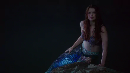 HD PC desktop wallpaper: Ariel from the TV show Once Upon a Time — a red‑haired mermaid perched on a rock, shimmering tail against a dark, moody background.