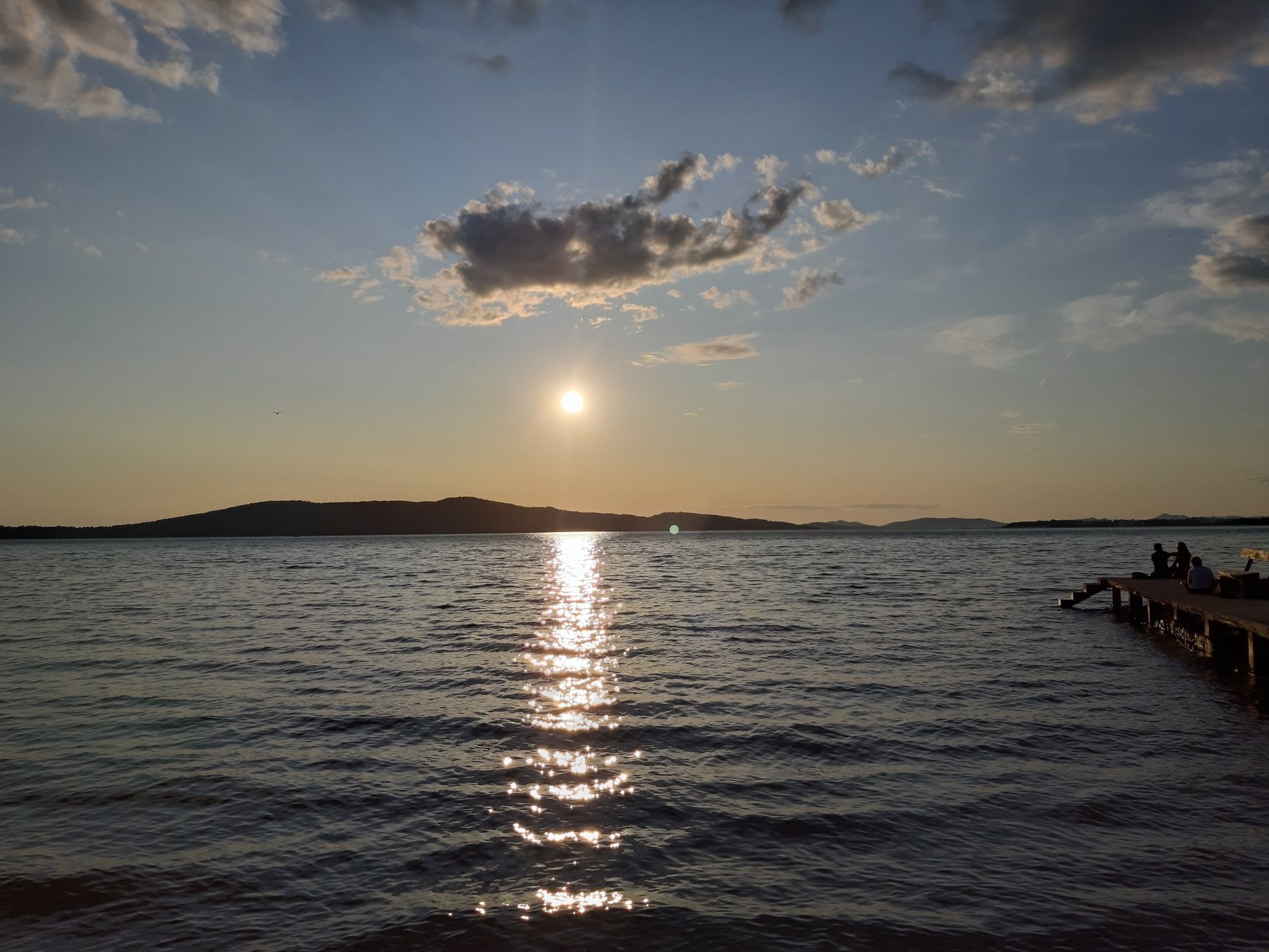 Sunset over the calm waters near Krapanj Island, Croatia, captured in a 4K Ultra HD landscape photograph with a peaceful pier on the right.