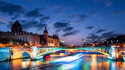 Night view of a brightly lit man-made bridge over the Seine River in Paris, captured in stunning 4K Ultra HD for a PC desktop wallpaper.