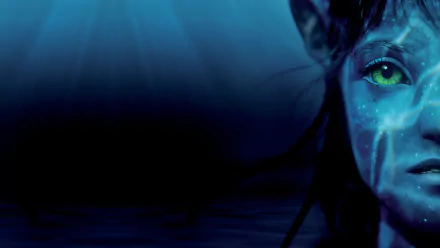 Close-up of a blue-skinned Navi character with glowing green eyes from the movie Avatar: The Way of Water, featured in a 4K Ultra HD PC desktop wallpaper.
