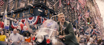 HD desktop wallpaper from Indiana Jones and the Dial of Destiny featuring a scene with a character in a parade, surrounded by American flags and confetti.