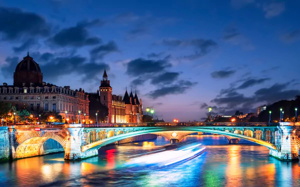 A magnificent view of a Parisian bridge at night, beautifully illuminated in this captivating HD desktop wallpaper.