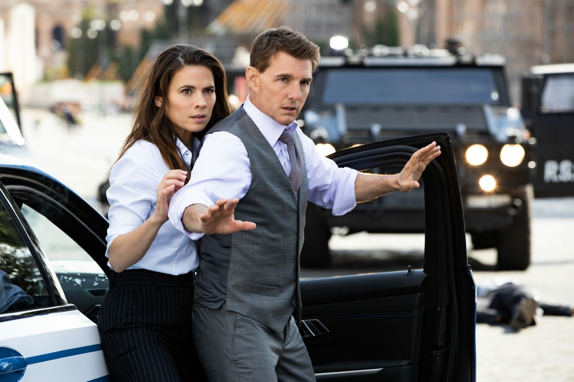 HD desktop wallpaper from Mission: Impossible - Dead Reckoning Part One, featuring two agents in action by a car.