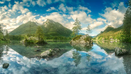 Stunning 4K Ultra HD desktop wallpaper of Hintersee lake capturing crystal-clear water reflections of lush trees and towering mountains under a vibrant blue sky.