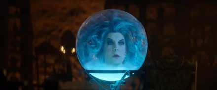 HD desktop wallpaper featuring a scene from Haunted Mansion with a character's face dramatically illuminated inside a crystal ball.