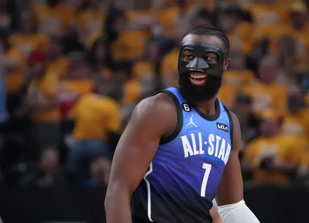 HD desktop wallpaper featuring Jaylen Brown in an NBA All-Star game uniform, smiling on the court with a cheering crowd in the background.
