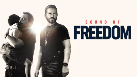 HD desktop wallpaper for the movie Sound of Freedom featuring two men, one comforting a child and the other in tactical gear.