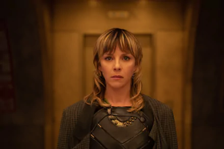 HD wallpaper of Sophia Di Martino as Sylvie Laufeydottir from Loki Season 2, posing in a detailed costume against a blurred golden background.