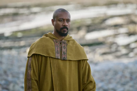 A character from the TV show *The Winter King* stands contemplatively in a golden cloak against a blurred natural backdrop, creating an engaging HD desktop wallpaper.