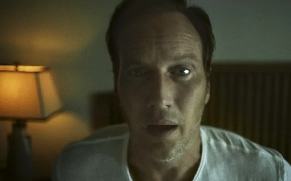 HD wallpaper of a suspenseful scene tagged as 'Insidious: The Red Door', featuring a man looking with an intense expression in a dimly lit room.