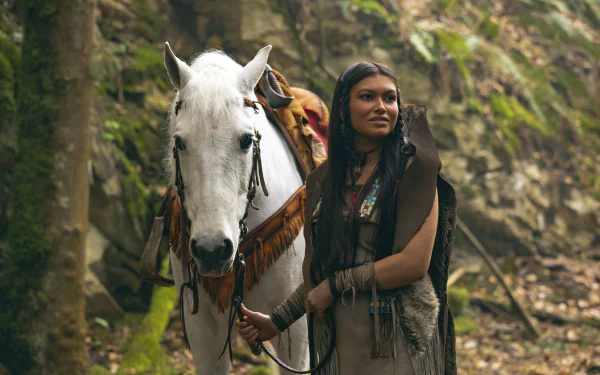 HD desktop wallpaper featuring a character reminiscent of Tiger Lily from Peter Pan standing next to a white horse in a natural, forested setting.