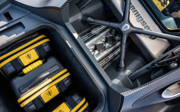 HD desktop wallpaper showing a detailed view of the interior and engine components of the Koenigsegg Gemera with carbon fiber finishes and yellow accents.