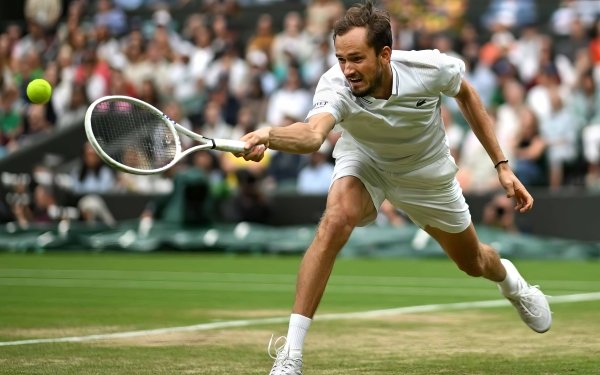 Daniil Medvedev reaching for a tennis ball at Wimbledon 2023 captured in a dynamic HD desktop wallpaper.