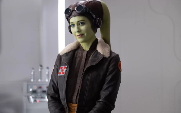HD desktop wallpaper featuring a character resembling Hera Syndulla from the Star Wars series, wearing pilot goggles and a flight jacket, with a soft-focused background.