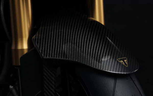 Close-up of the Triumph Speed Triple 1200 RR Bond Edition, showcasing its sleek carbon fiber details against a dark background. A striking HD desktop wallpaper for motorcycle enthusiasts.
