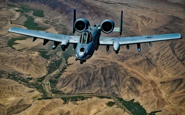 A high-definition desktop wallpaper featuring a military A10 aircraft in action.