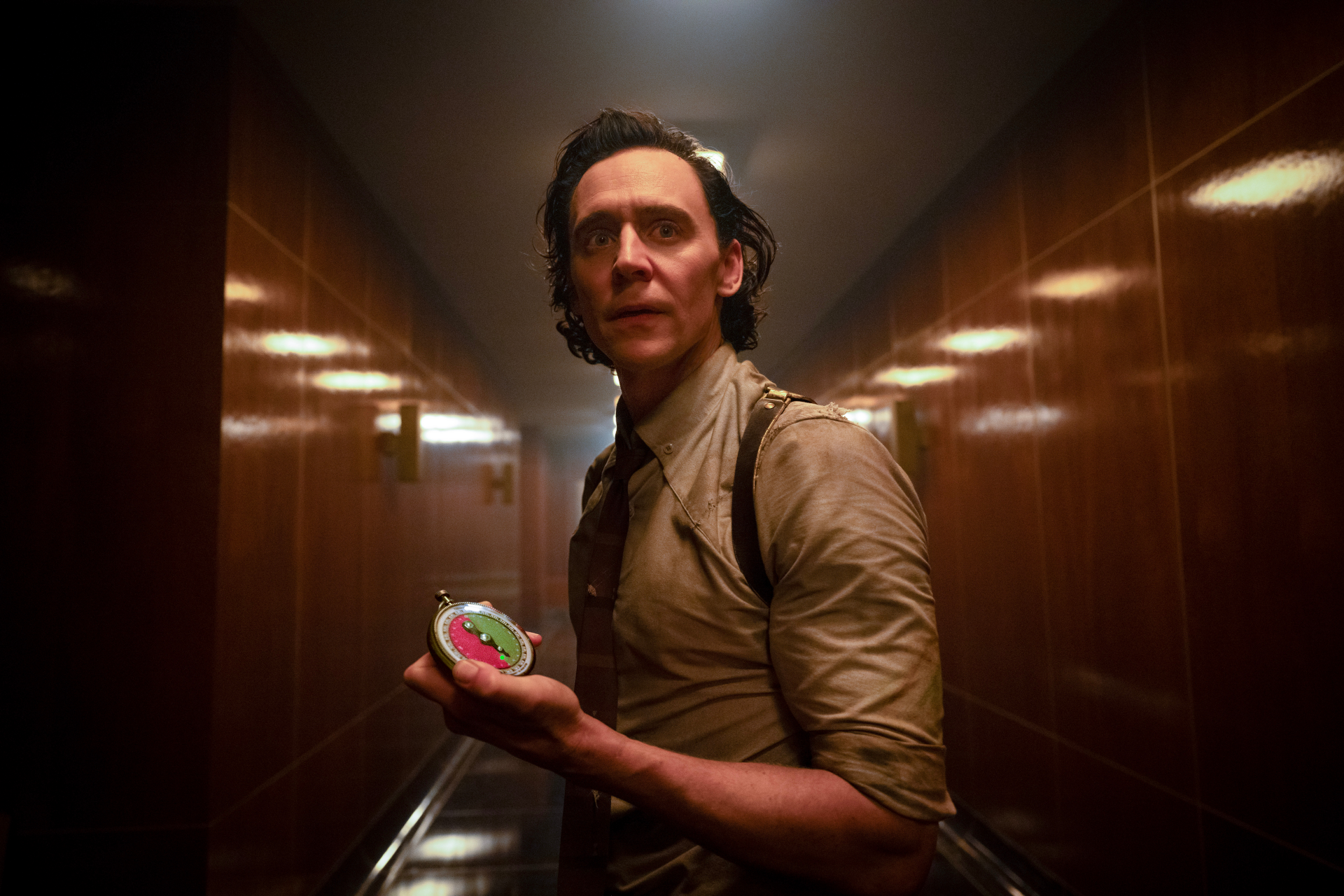 High-resolution desktop wallpaper featuring a character resembling Loki, portrayed by an actor in a dimly lit corridor, holding a mysterious object.