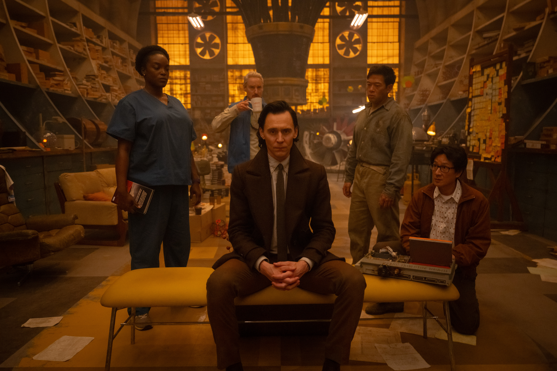 HD wallpaper featuring Loki from Marvel Comics, sitting confidently in the center, surrounded by key characters from the Loki TV show in a stylized, atmospheric setting.