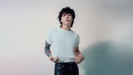 Jungkook from BTS poses confidently in a stylish outfit, showcasing his unique style in this vibrant HD desktop wallpaper, celebrating his influence in music.