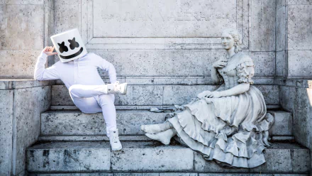HD wallpaper of Marshmello sitting next to a statue on steps, providing a modern and classical visual contrast.