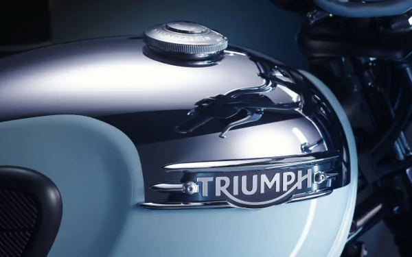 Close-up HD wallpaper of a Triumph Bonneville T120R motorcycle with a shiny chrome edition tank emblem.