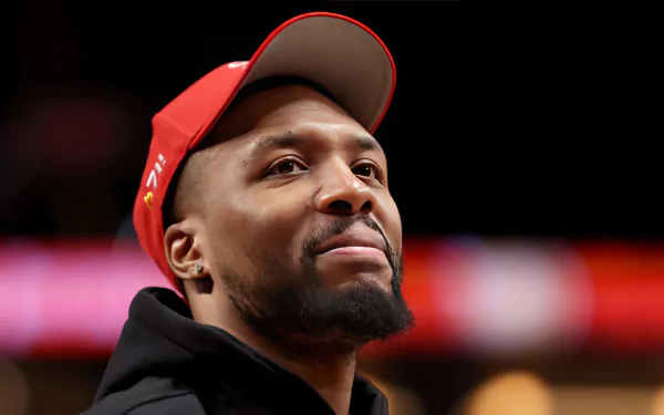 Alt-text: HD desktop wallpaper featuring a smiling man in a red cap and black attire, providing an inspirational background image for sports enthusiasts.