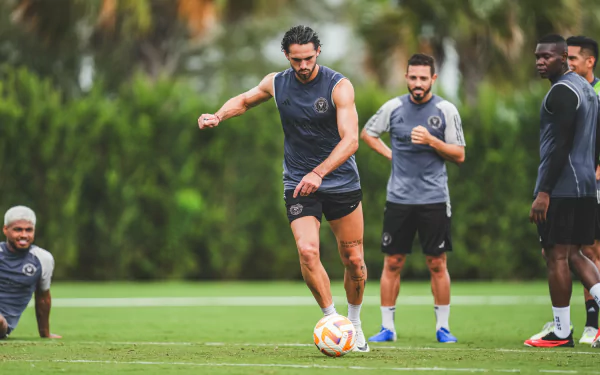 Inter Miami CF player demonstrates ball control during training on a lush green field, with teammates in the background, in a vibrant HD desktop wallpaper and background.