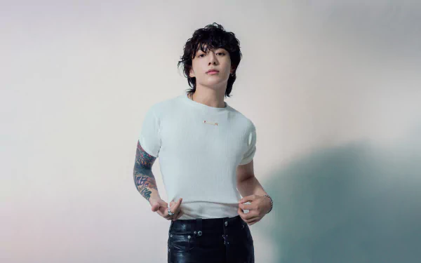 HD desktop wallpaper featuring a male K-pop idol in a casual white shirt and black pants, showcasing a trendy hairstyle and visible tattoos, with a soft-focus background, perfect for fans of BTS.