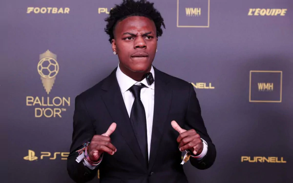 A celebrity poses confidently in a black suit and tie against a stylish backdrop, creating a striking HD desktop wallpaper featuring IShowSpeed.